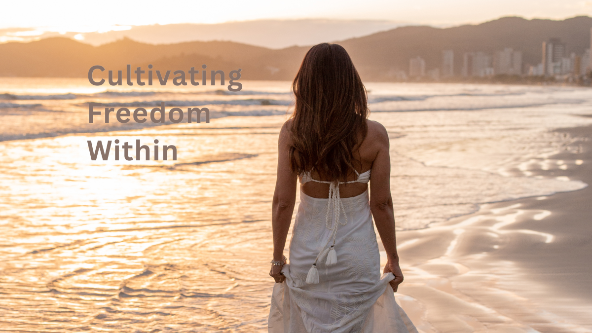 A woman in a white dress walking barefoot along the shoreline at sunset with the title “Cultivating Freedom Within,” symbolizing reflection, openness, and inner freedom.