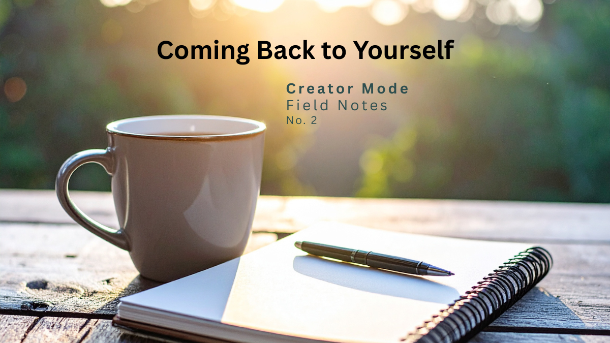 Morning sunlight illuminates a coffee mug, notebook, and pen on a rustic wooden table with the title "Coming Back to Yourself" – Creator Mode Field Notes No. 2.